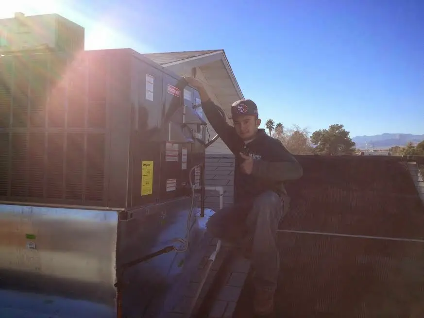 HVAC technician performing AC Tune-Up on a rooftop unit in Pleasantville